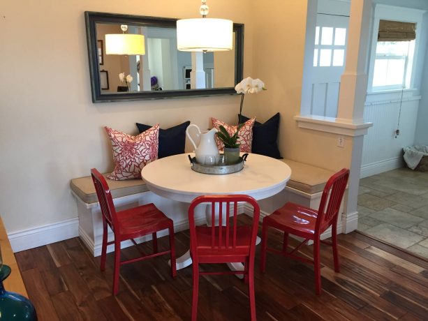 a white breakfast nook with black and red accents