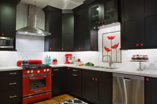 bold eclectic kitchen with dominant black cabinets that are paired with white subway tile backsplash and stunning red oven stove