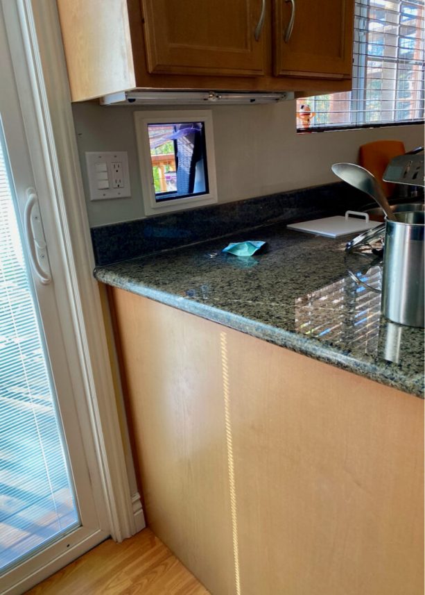 The cat door insert is located on the wall near the kitchen counter