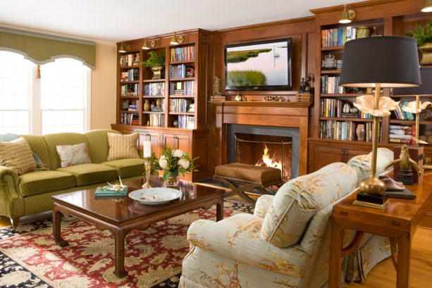 a strong and cozy traditional look resulted from the custom, stained wood fireplace and bookshelves