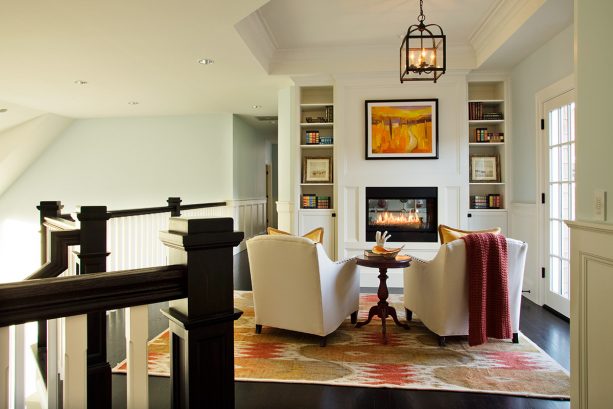 custom fireplace and bookshelves built in a small space near the staircase