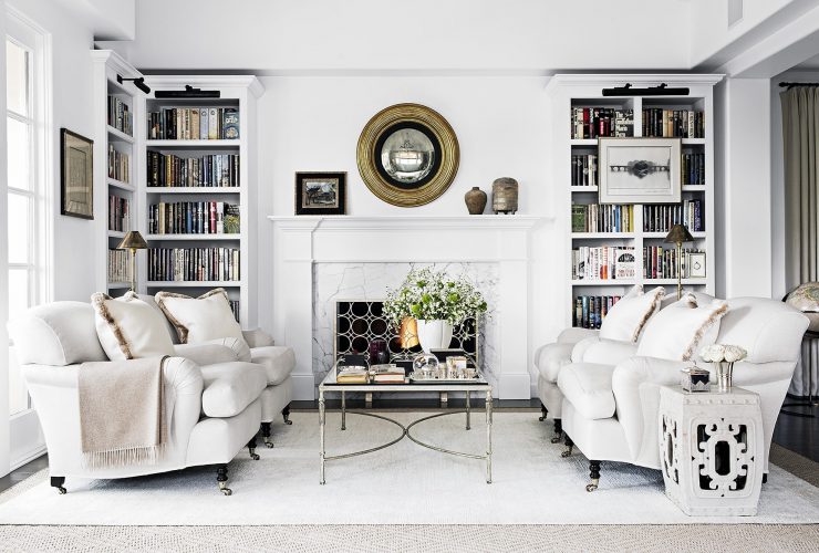 elegant and luxurious design of a classic, traditional white fireplace with custom white bookshelves surrounding it