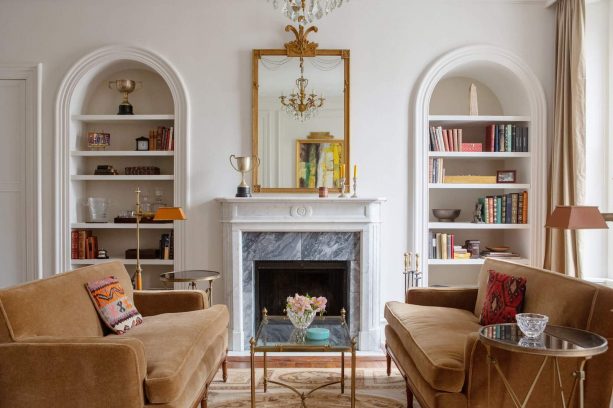 wall-built-in bookshelves flanking a gorgeous fireplace with marble filler panel