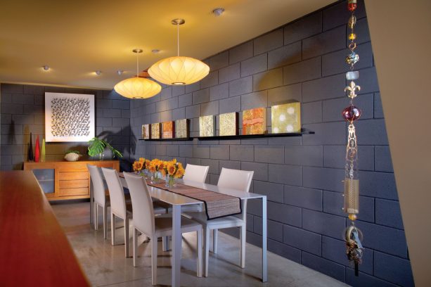 a contemporary dining room with grey cinder block walls