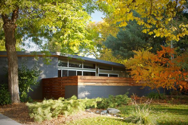 a home exterior showing a striking combination between dark grey cinder block and tigerwood walls