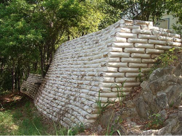 a large retaining wall from concrete bags built behind a house