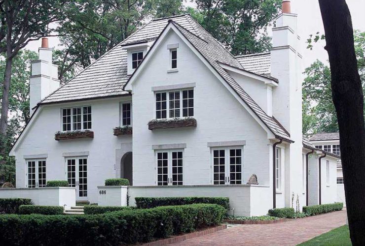 a traditional home exterior design with cinder block walls painted in white