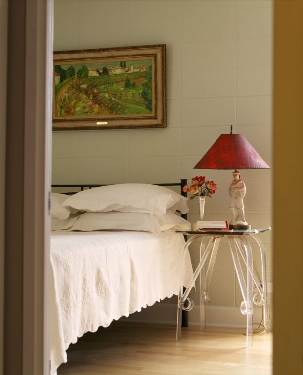an eclectic bedroom with beige cinder block walls