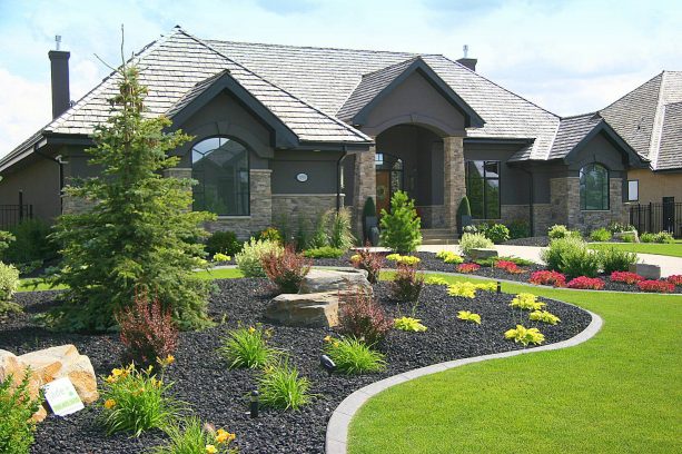 a beautiful combination of lawn, black lava rock, and decorative plants