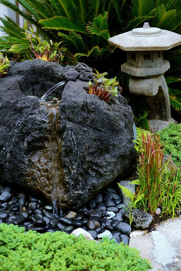 a carved, black lava rock fountain by Ben Oki as a part of a peaceful Japanese zen garden landscape