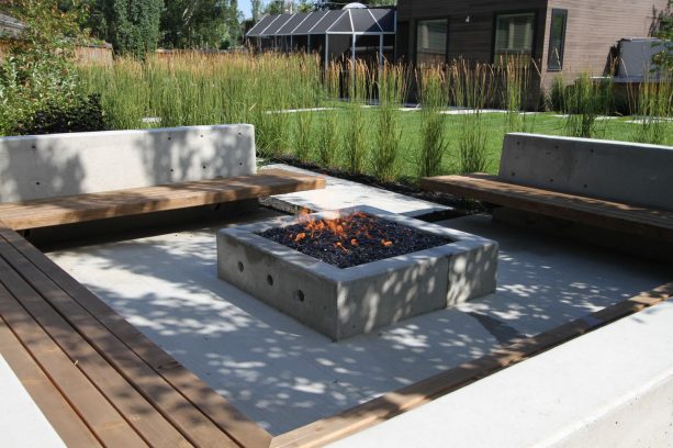 an outdoor living area with fireplace at the end of the concrete walkway