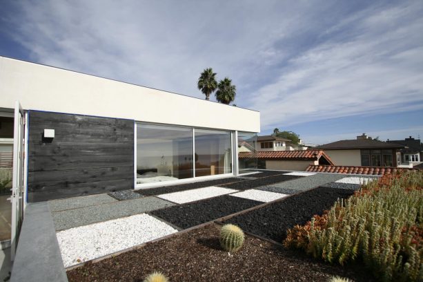 the black lava rock is paired with other rock types to create a modern landscape design