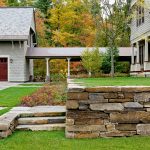 the covered walkway connects the house and the garage while offering the beautiful views of the woods and garden landscape