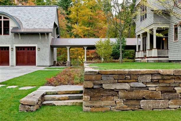 the covered walkway connects the house and the garage while offering the beautiful views of the woods and garden landscape