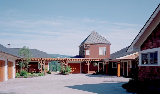 the long walkway between the garage and the house is covered with pergola