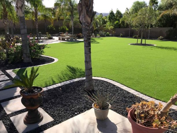 the pairing between black lava rock and artificial lawn in a landscape