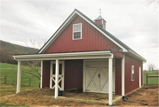 a red pole barn completed with a loft and a covered porch