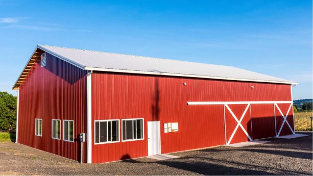 a red pole barn located in agricultural area