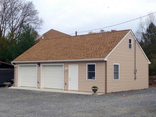 beige theme pole barn garage with a window under the roof, marking the existence of a loft inside it