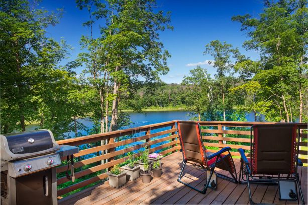 the deck is completed with chairs and a grilling station