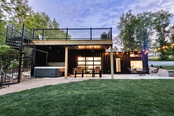 the elegant shipping container tiny house with roof deck accessible through the spiral staircase