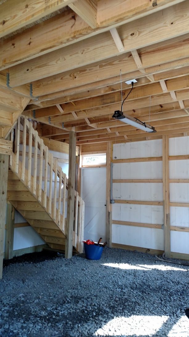 the interior of the pole barn garage showing a staircase to access the workspace above