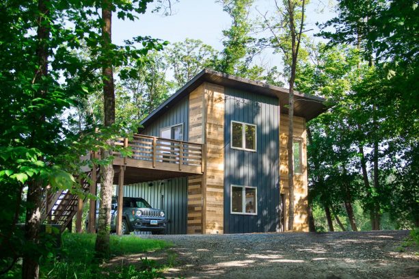 the multicolor tiny house has wooden deck functioned also as a carport cover