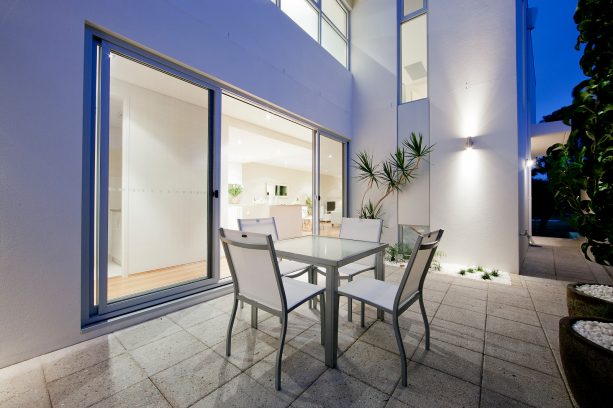 a backyard patio with complete table and chair set for alternative eating place in the modern courtyard house