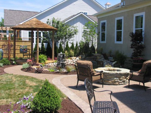 a beautiful backyard garden with exposed aggregate-style concrete walkway and patio