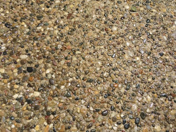 a close-up appearance of an exposed aggregate surface with gloss sealer