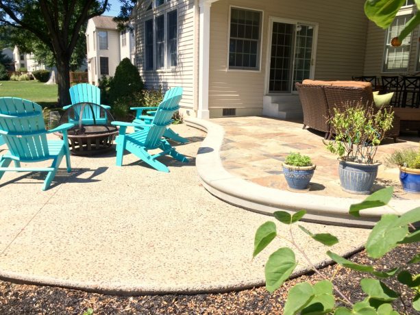 a concrete patio with exposed aggregate style becomes an extra living space for the modern house