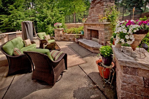 a contemporary patio design looks fabulous with a stone fireplace and exposed aggregate concrete floor