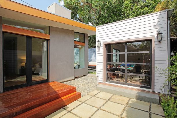 a detached contemporary shed with a glass sectional garage door functioned as an art studio
