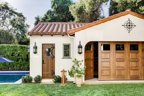 a Mediterranean shed with folding garage door and cozy ivory white exterior