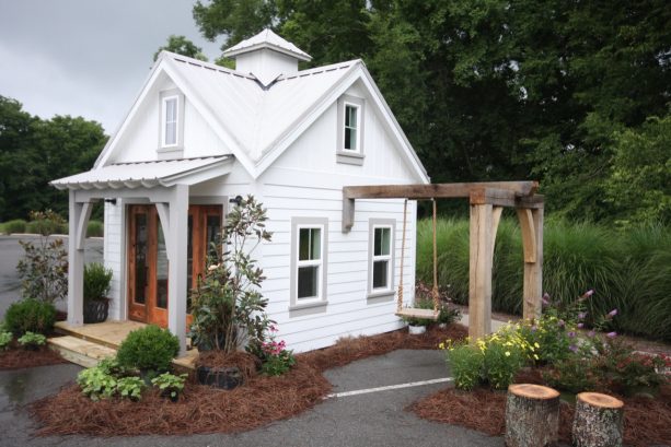 a traditional shed with accordion garage door with glass detail