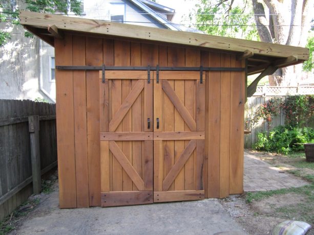 an eclectic wooden garden shed with sliding barn garage door