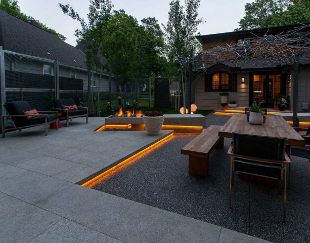 exposed aggregate concrete and stone slabs looks trendy being combined in a contemporary patio design