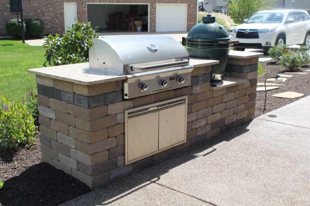 on the left side of the patio, there is small kitchen area with a grill and a smoker