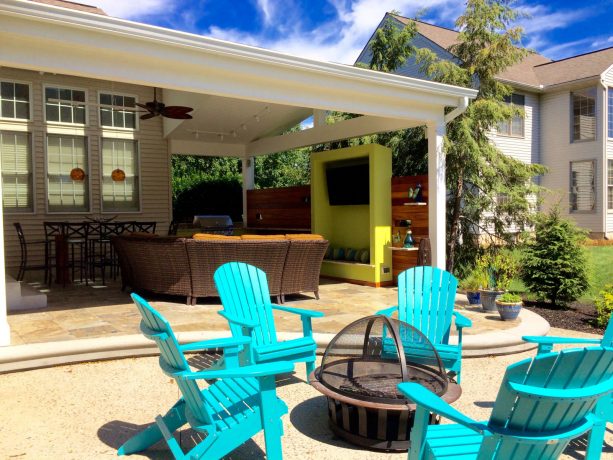 the exposed aggregate patio is connected to an open kitchen with outdoor dining-living room