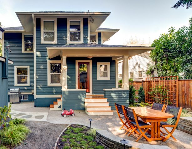 the traditional backyard is completed with exposed aggregate patio and an outdoor dining area