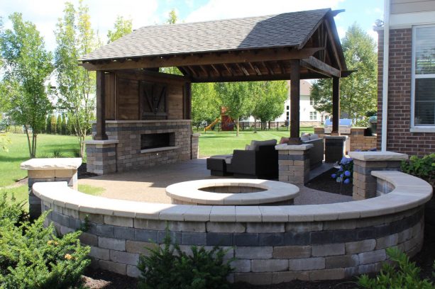 there is a round fire pit with seatwall on the right side of the patio