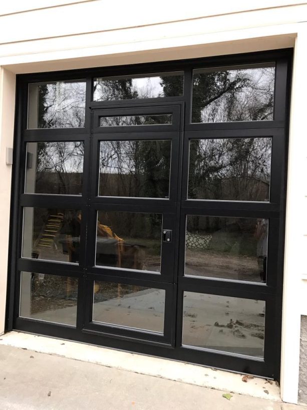 a black, contemporary aluminum and glass garage door with a middle passage