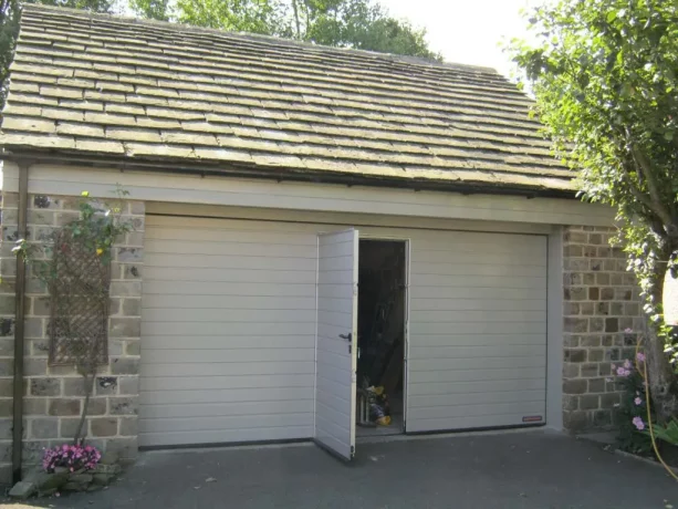 a simple white sectional garage door with a wicket feature