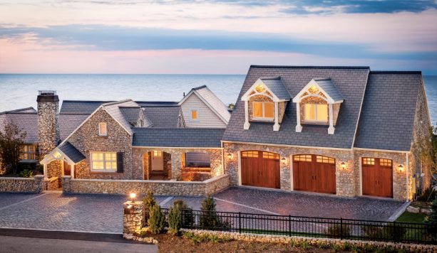 an inviting combination between the faux wood garage doors and the natural stone exterior walls