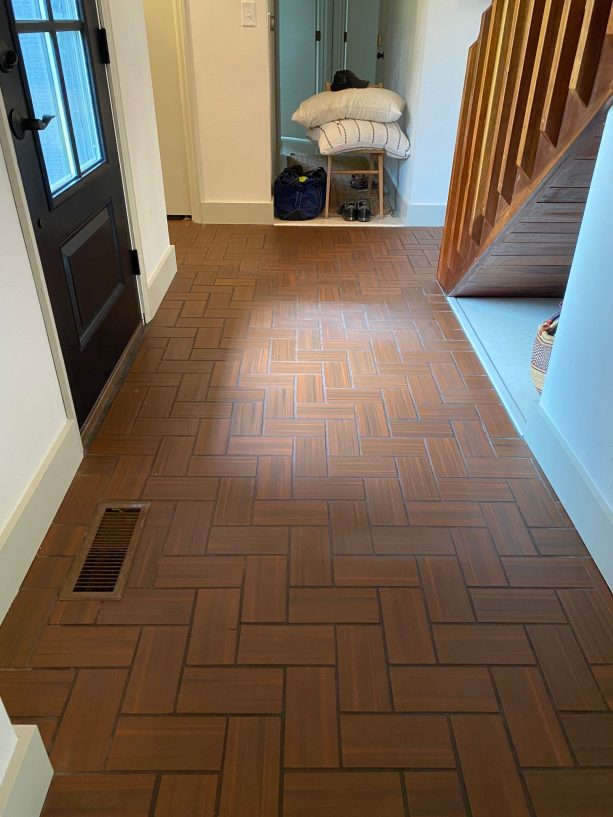 the entry and hallway reddish-brown ceramic straight herringbone before getting painted to look like slate