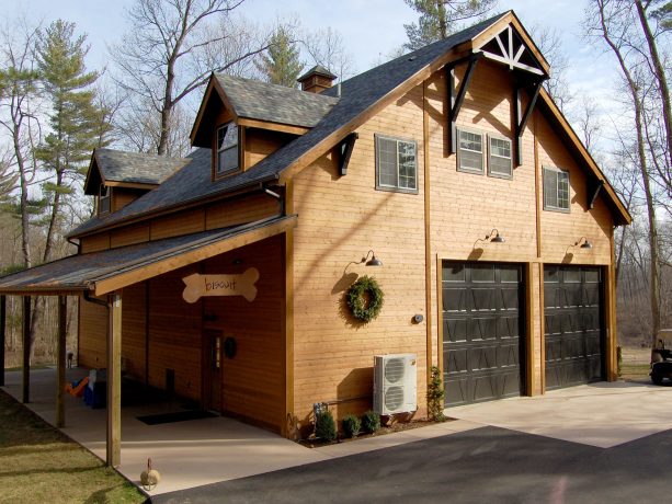 the wood siding exterior looks contrast with the black garage doors