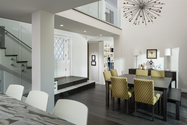 a contemporary open dining room with dark wood floor