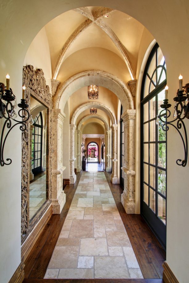 a mediterranean hallway with dark hardwood and multitone natural stone floor