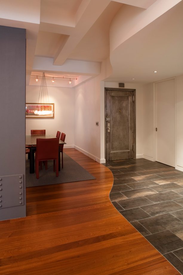 a trendy entryway with the combination between dark wood floor and porcelain tile