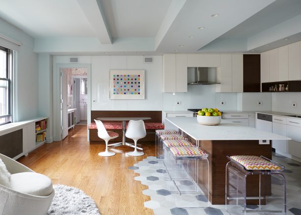an open kitchen-dining room with trendy floor from hardwood and multi-tone hexagonal tiles